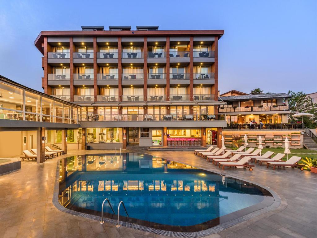 a hotel with a swimming pool in front of a building at Kilya Hotel in Kilyos