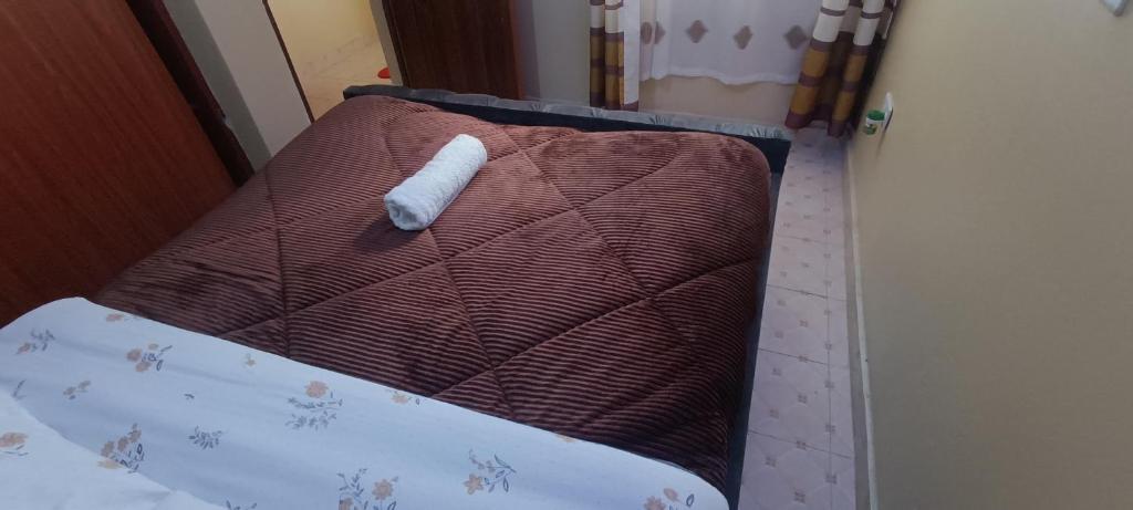 a bed with a white object on top of it at Serene Studios Kamakis Eastern bypass in Ruiru