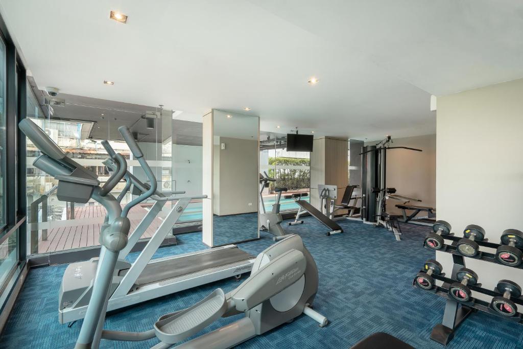 A compact hotel gym combining cardio machines, weights and resistance equipment.