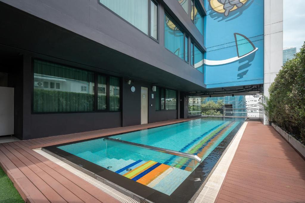 A narrow outdoor pool running alongside the hotel building.