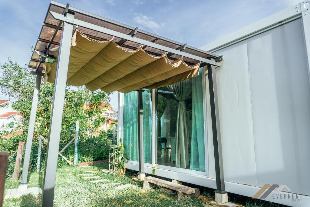 une maison en verre avec un auvent sur son côté dans l'établissement Evernent Lakeside Hideout, à Miri