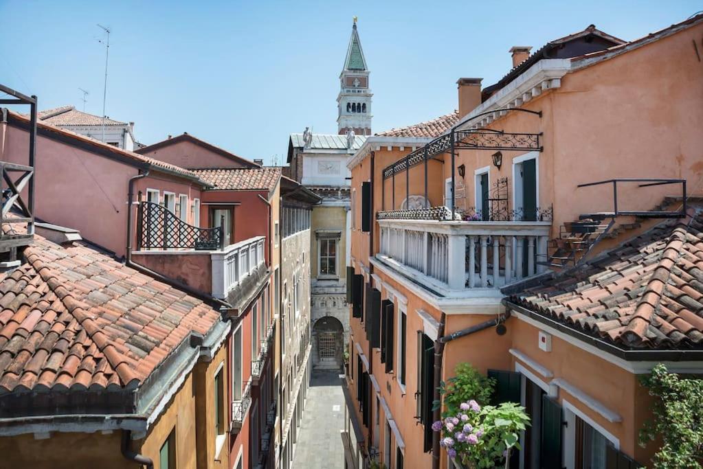 un vicolo tra edifici con una torre dell'orologio sullo sfondo di Incredible location in San Marco's Square, Venice a Venezia