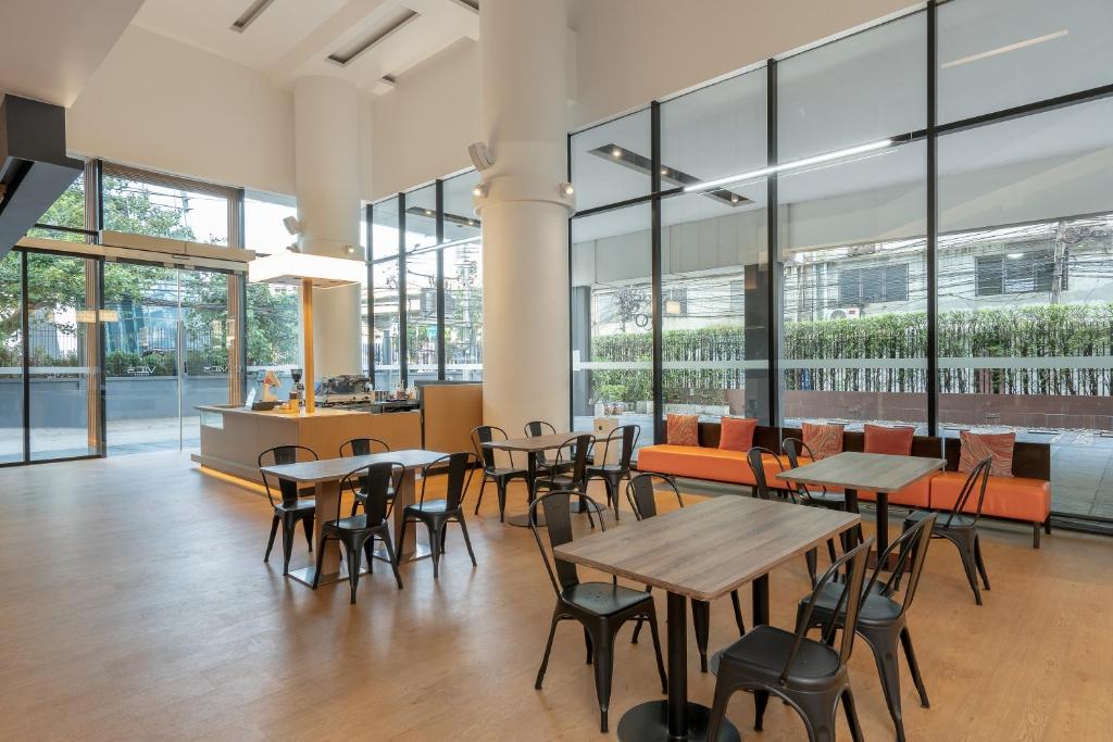 A bright, open dining room with café tables and a windowed seating area.
