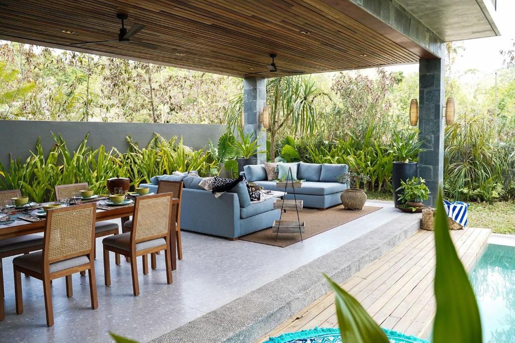 un patio con sofá, mesa y sillas en Pandan Villas, El Nido en El Nido