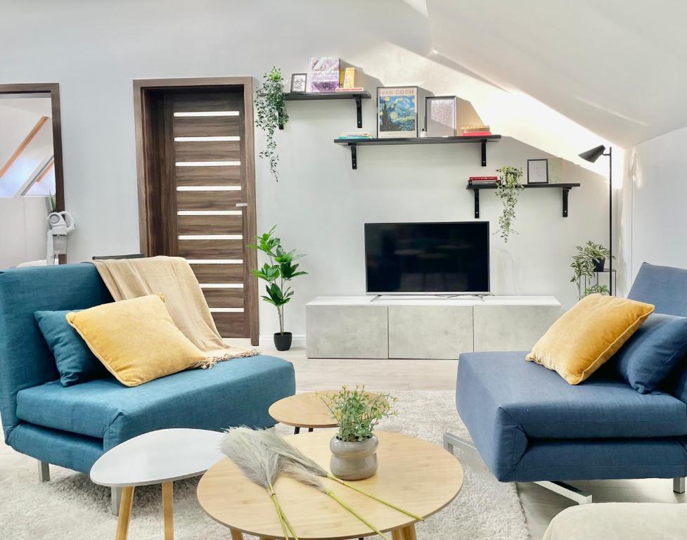 a living room with two blue couches and a tv at Spacious ultracentral modern apartment in Târgu-Mureş