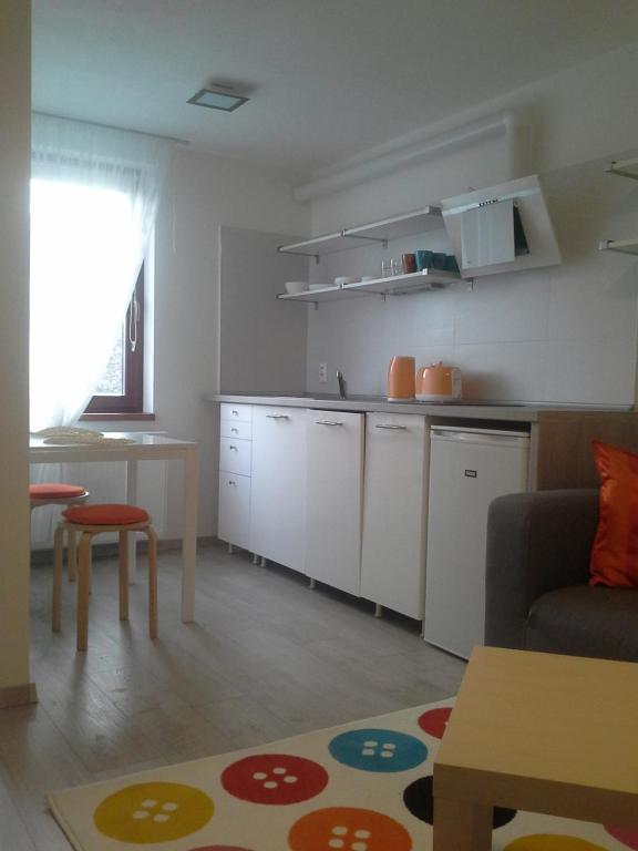 a living room with a kitchen and a table at JANA apartments in Bratislava
