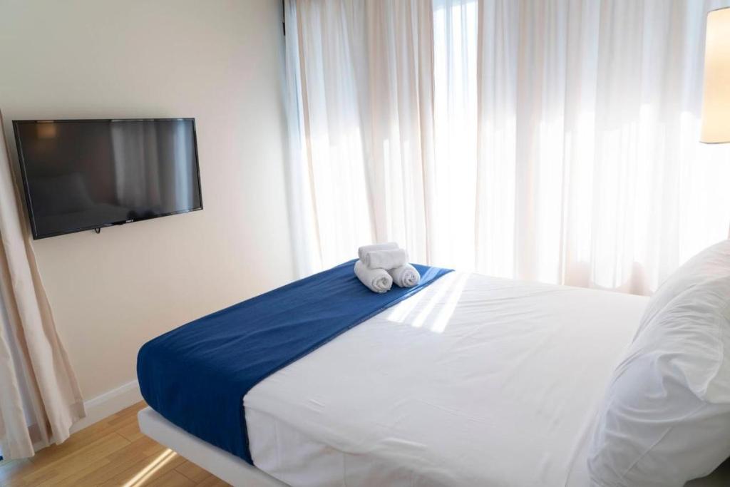 un osito de peluche sentado en una cama en un dormitorio en Orbi Apartment, en Batumi