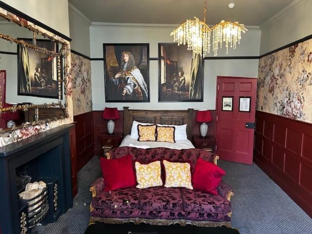 um quarto com uma cama e um lustre em Golden Fleece York em York