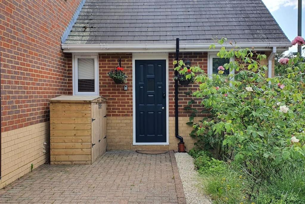 ein Backsteinhaus mit einer blauen Tür und einem Fenster in der Unterkunft Self-contained Guest Suite in Guildford