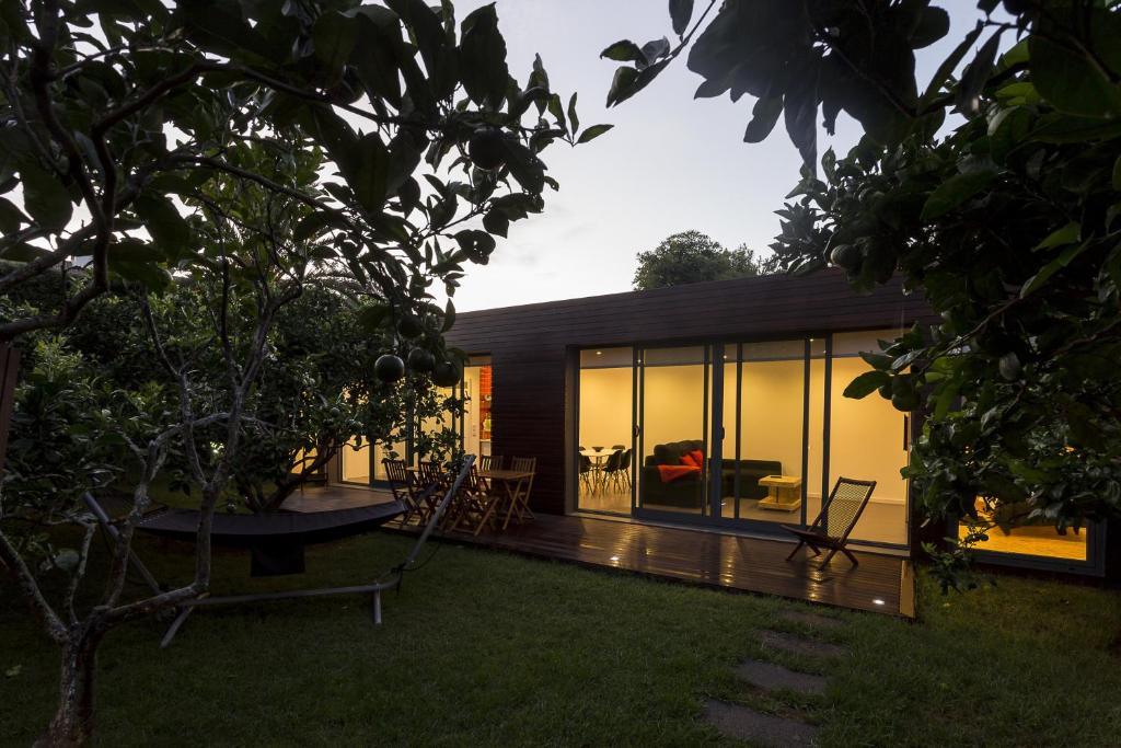 uma casa com paredes de vidro e um quintal em Quinta das Rosas Villas na Ribeira Grande