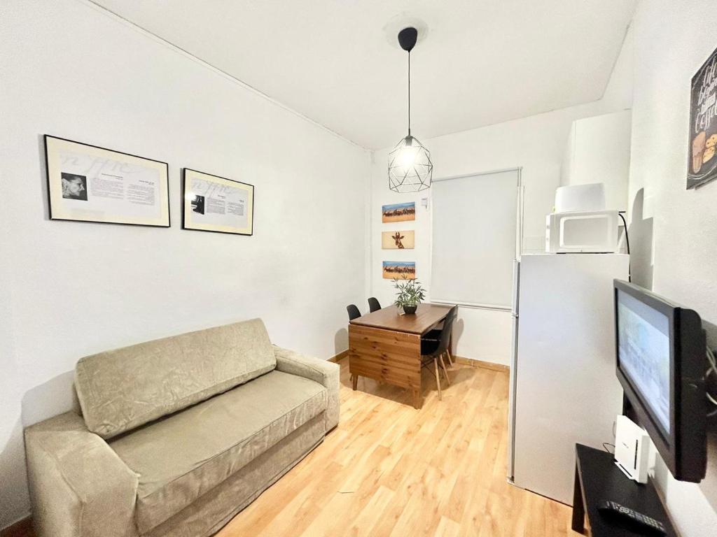 een woonkamer met een bank en een koelkast bij Madrid Rio Antonio López B in Madrid