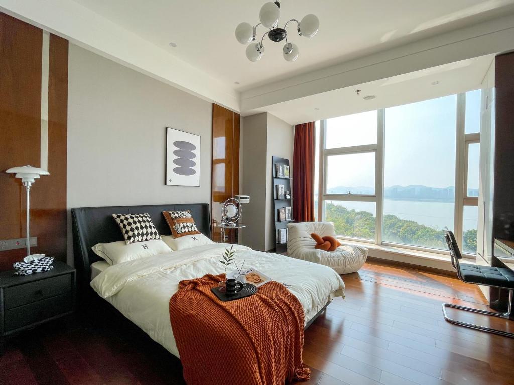 a bedroom with a large bed and a large window at Lexiangjia - Riverview Apartment in Hangzhou