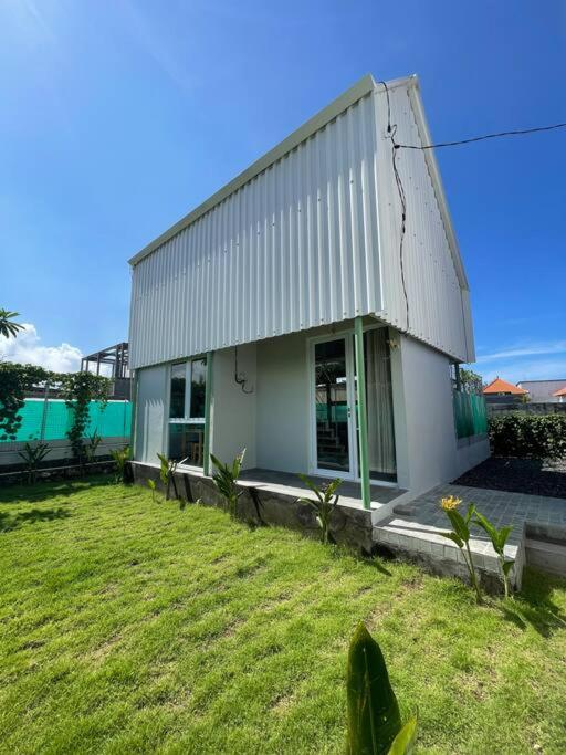 a building with a grassy yard in front of it at Monty’s Villa Umalas - 1 Bedroom in Kerobokan