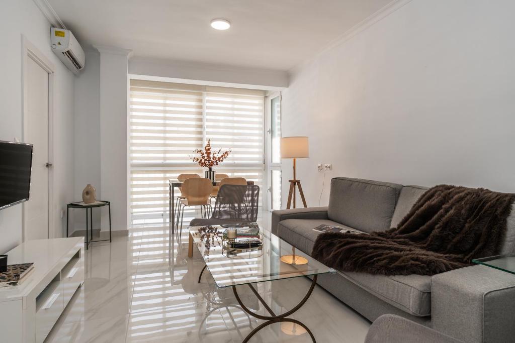 ein Wohnzimmer mit einem Sofa und einem Tisch in der Unterkunft tuGuest Alhamar Apartment in Granada