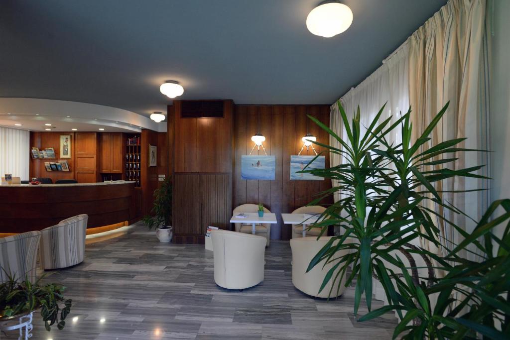 a lobby with a potted plant and a waiting room at Hotel Giulio Cesare in Cinquale