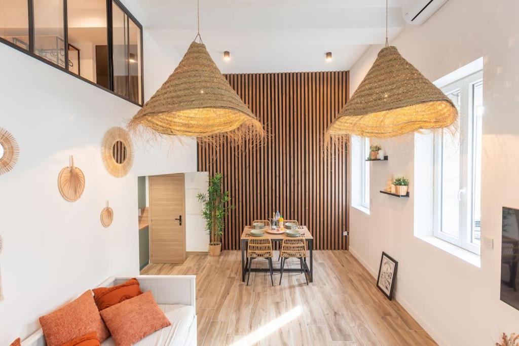 - un salon avec une table et deux lustres dans l'établissement Jungle Room de Charme, à Marseille