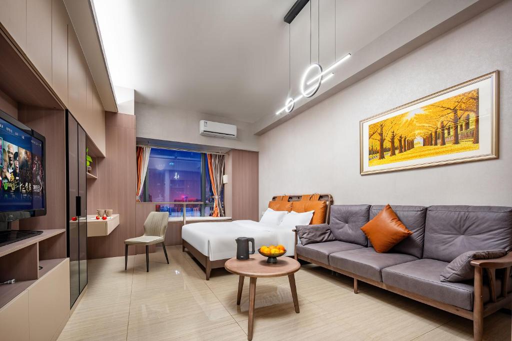 uma sala de estar com um sofá e uma cama em Orange Apartments em Chengdu