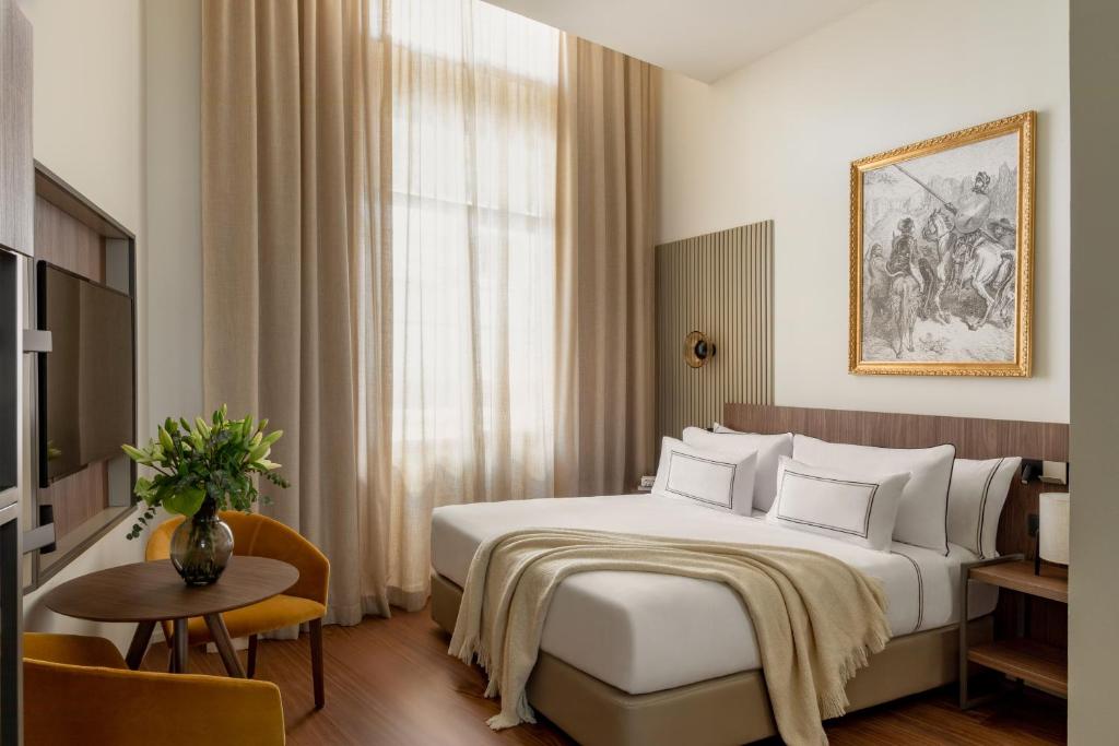 a hotel room with a bed and a table at Casa de las Artes, member of Meliá Collection in Madrid