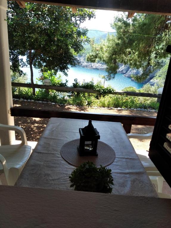 a table with a candle on it with a view of a river at Ioanna's house #dialiskari1# in Limnionas