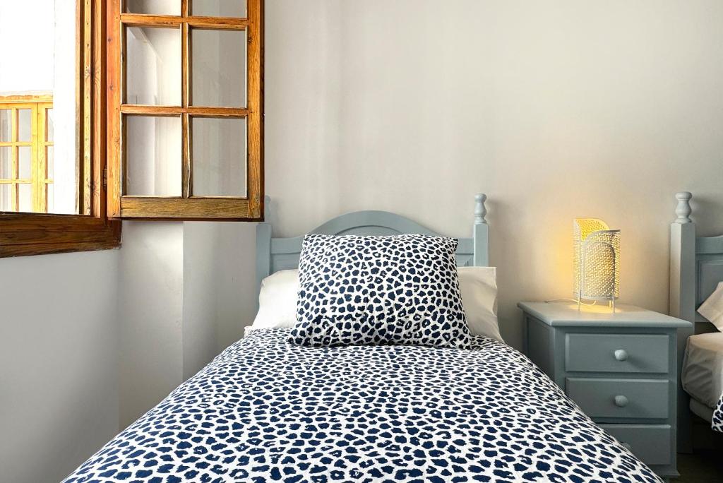 a bedroom with a bed with a pillow and a window at Apartamentos Vela Blanca in San José