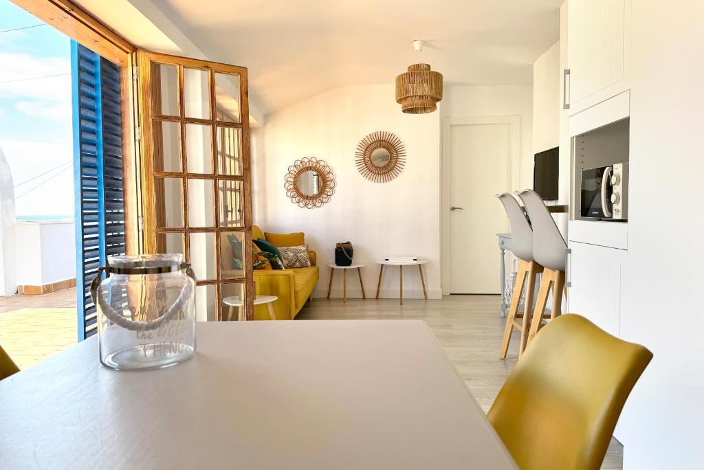 a kitchen and living room with a table and chairs at Apartamentos Vela Blanca in San José