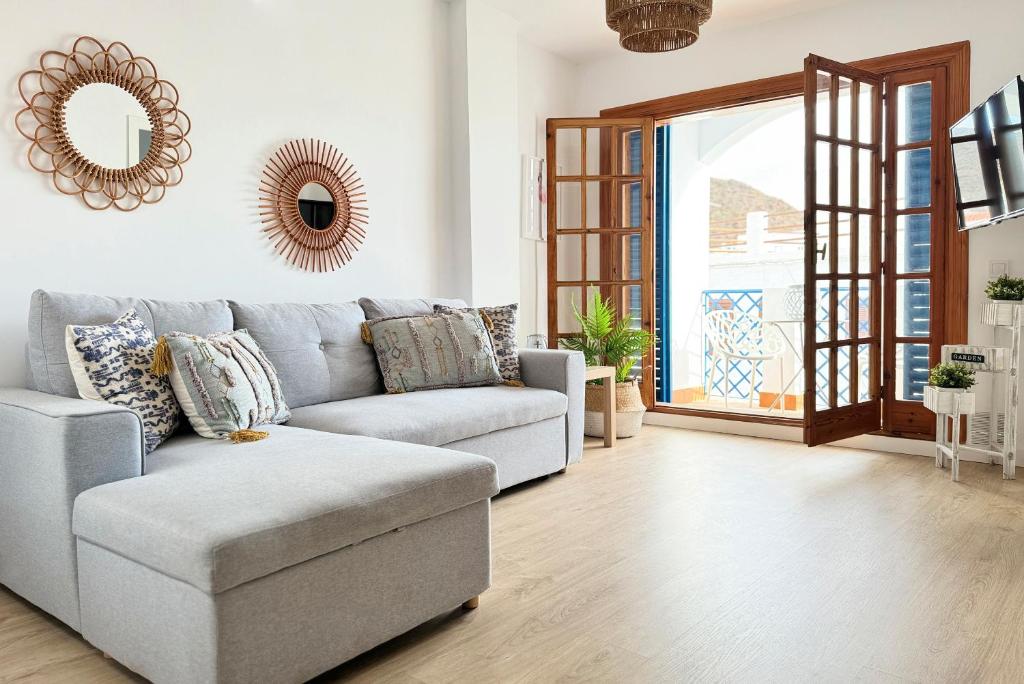 a living room with a couch and a mirror at Apartamentos Vela Blanca in San José