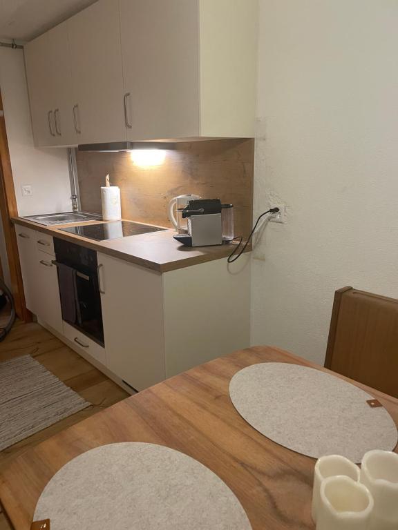 eine Küche mit einem Tisch und einer Arbeitsplatte in der Unterkunft Studio Chalet Sunnehöckli in Hasliberg