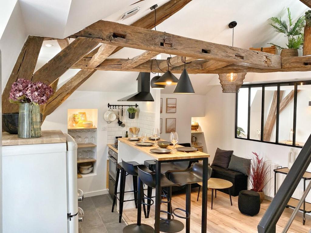 cocina y comedor con mesa y sillas en Home - Le repère des sommeliers, en Auxerre