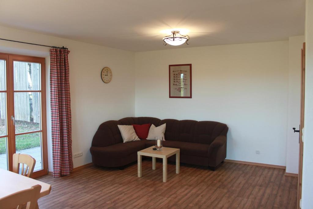 un soggiorno con divano e tavolo di Urlaubshof Grimm a Egling