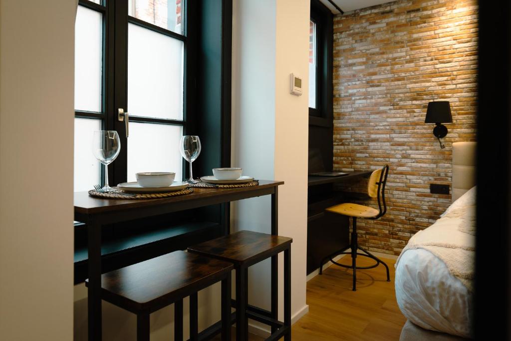 a room with a table with glasses and a bed at Le Pèlerin in Mons