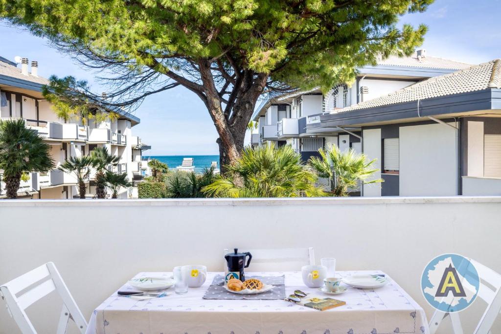 uma mesa com um prato de comida numa varanda com o oceano em Le Palme 50a em Silvi Paese