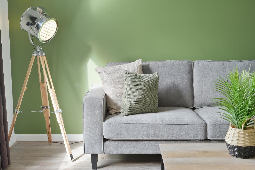 un salon avec un canapé gris et une lampe de chevet dans l'établissement Home from Home - Mersey Way, Spacious 3 Bed, Perfect for Workers, Groups & Families, Netflix, FREE Parking & EV Charge Point, à Sheffield