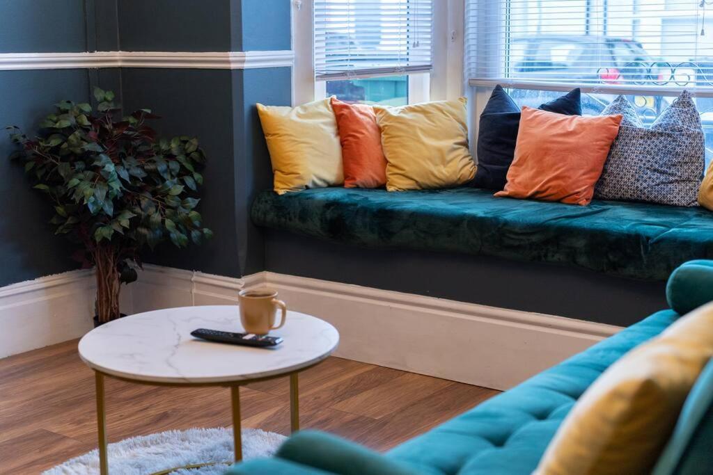 uma sala de estar com um sofá com almofadas coloridas em Open Mind Property - 5 Bedroom Lovely Home with Free Parking em Portsmouth