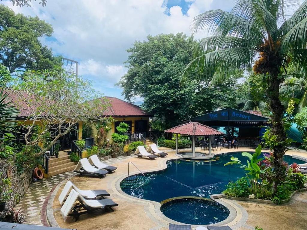 a swimming pool with lounge chairs and a resort at patong beautiful pool villa in Patong Beach