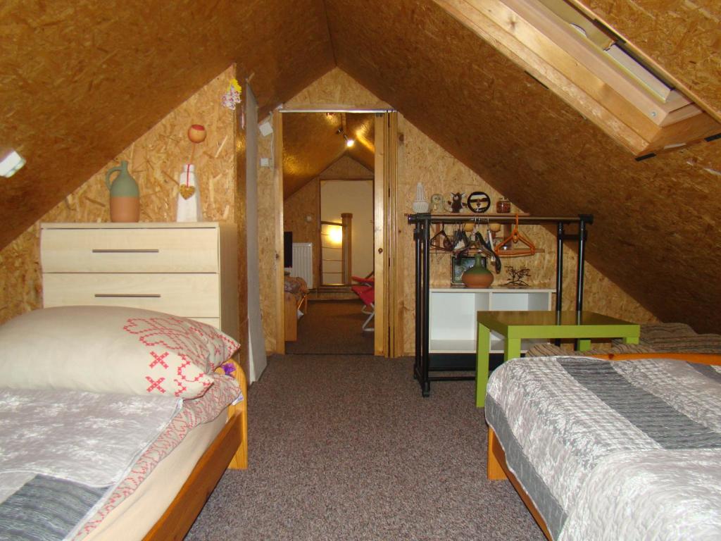 a attic room with two beds and a mirror at DOM POD LIPAMI in Wojsławice