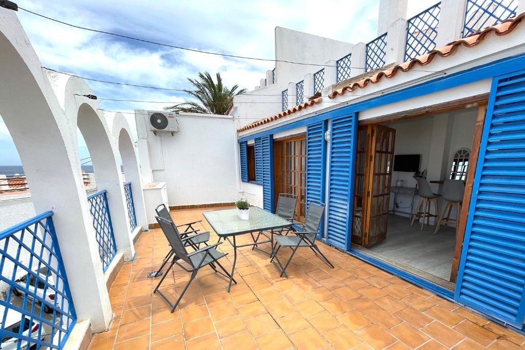 a patio with a table and chairs on a balcony at Apartamentos Vela Blanca in San José