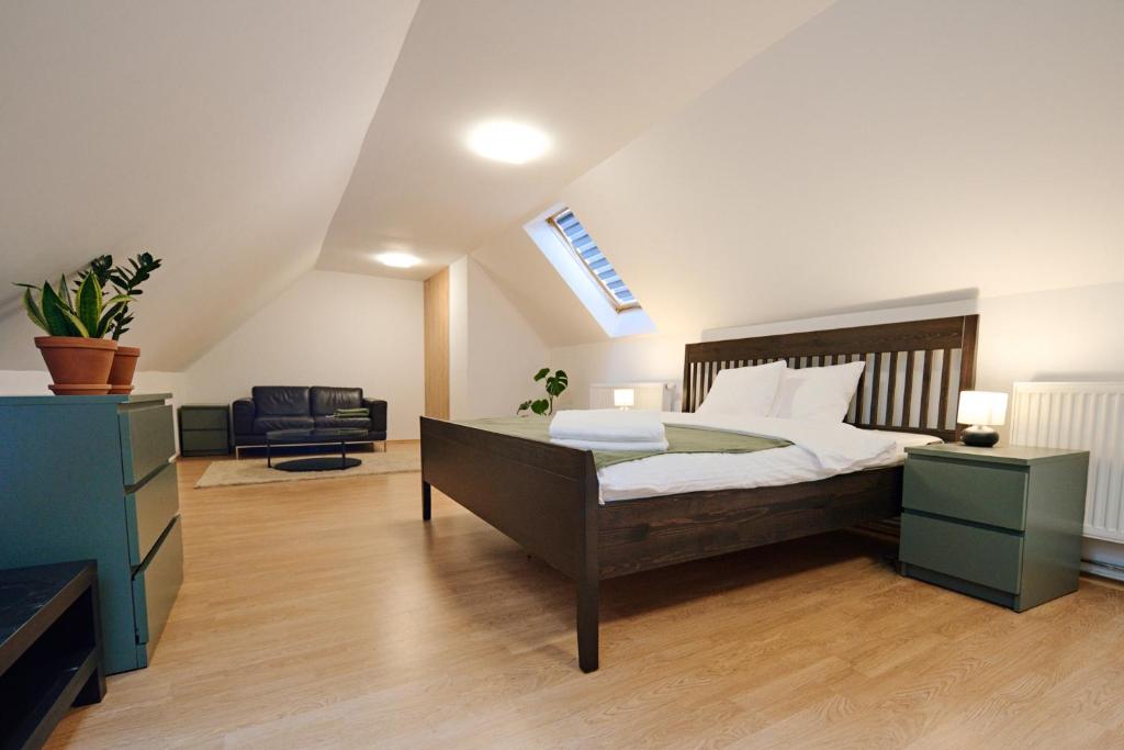 a bedroom with a large bed and a chair at Kesta Apartmán in Martin