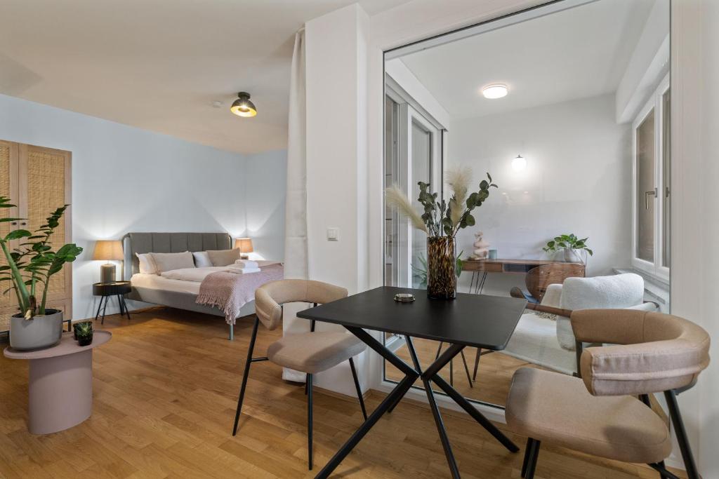 ein Wohnzimmer mit einem Tisch und Stühlen sowie ein Schlafzimmer in der Unterkunft ma suite - cozy apartment 2P - best location - private Parking in Augsburg