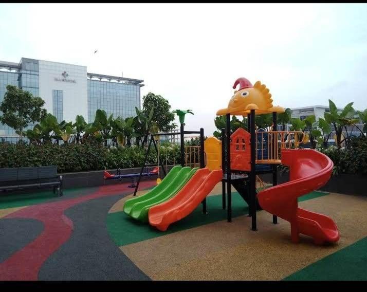 a playground with a slide in a park at Studio Healing Sayana Apartment in Tambun-lobangbuaja