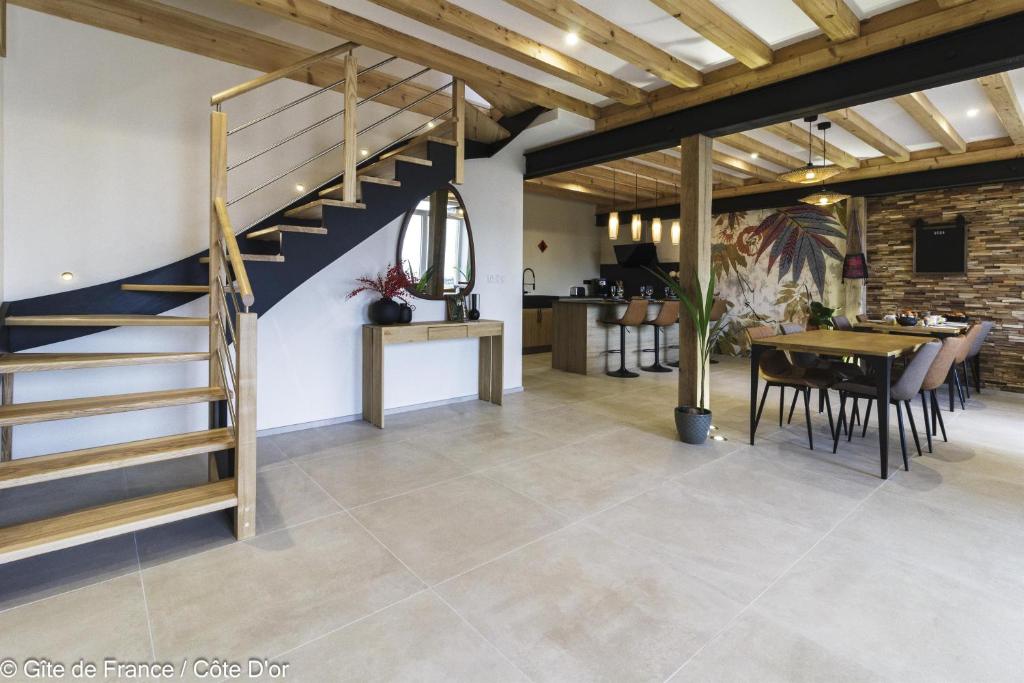 ein Esszimmer mit einer Treppe und einem Esstisch in der Unterkunft FORMOSA DIJON in Étaules