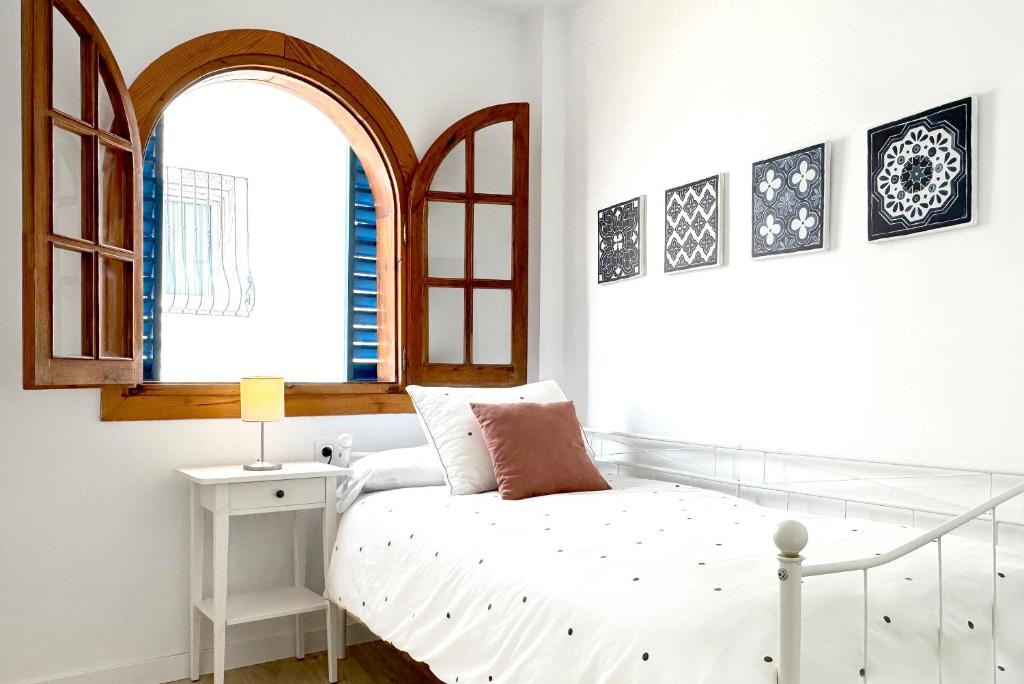 a bedroom with a bed and a window at Apartamentos Vela Blanca in San José