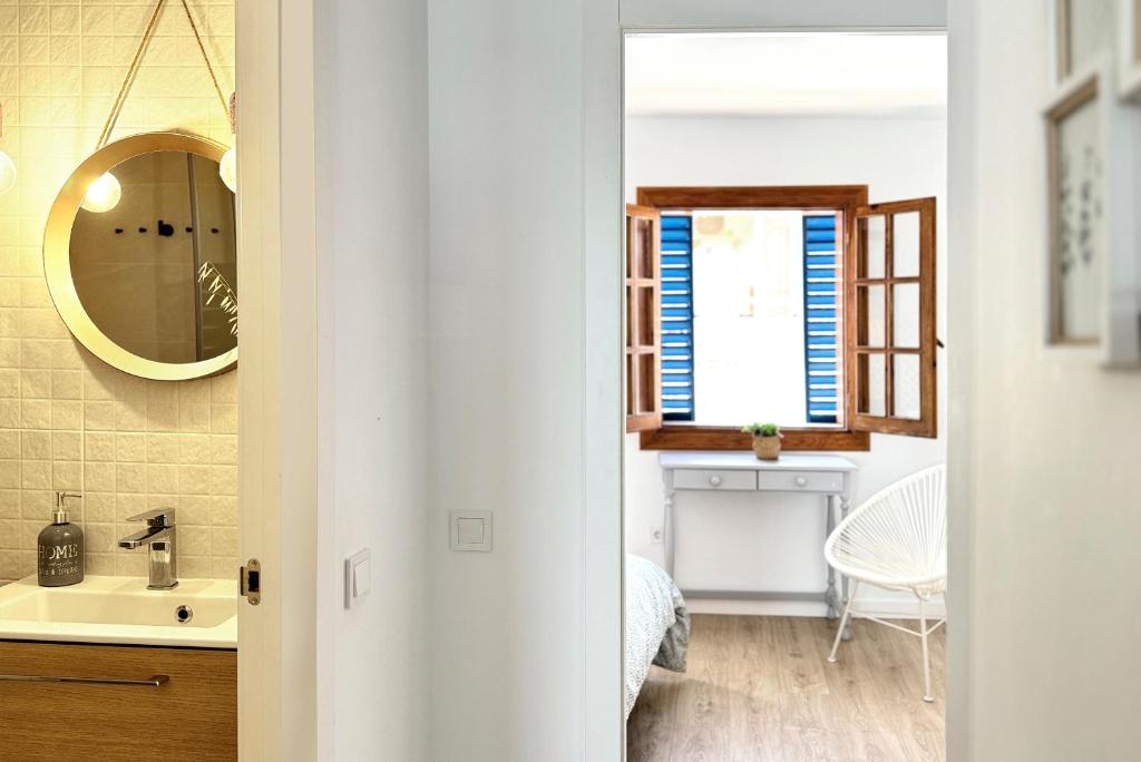 a bathroom with a sink and a mirror at Apartamentos Vela Blanca in San José