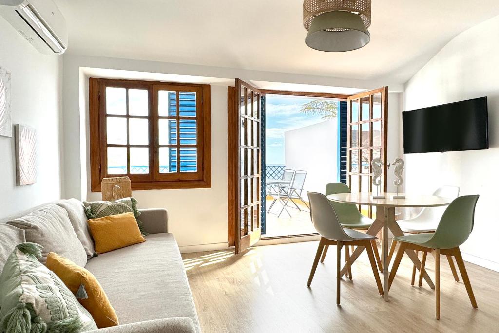 a living room with a couch and a table and chairs at Apartamentos Vela Blanca in San José