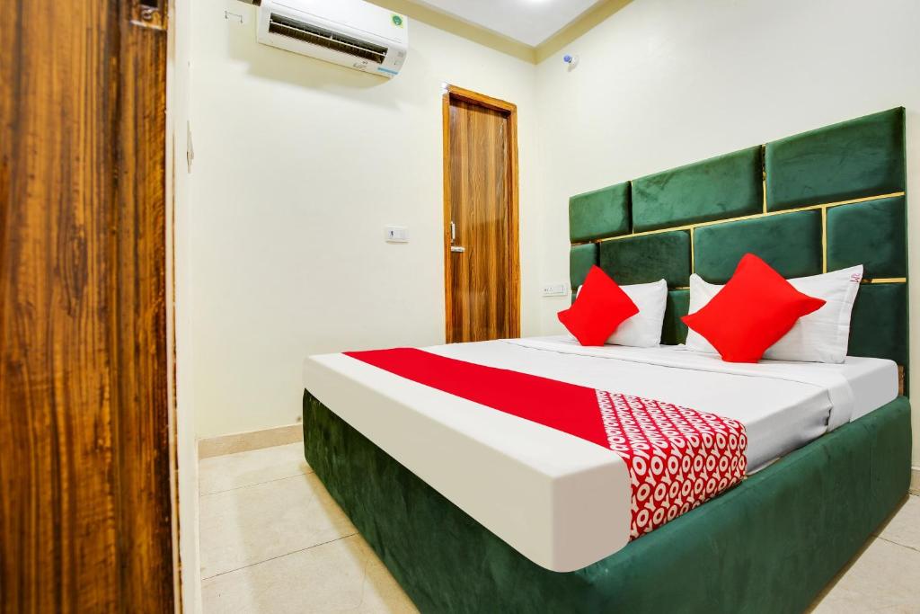 a bedroom with a large bed with red pillows at OYO Flagship 80943B Hotel Blue Shine in Ludhiana