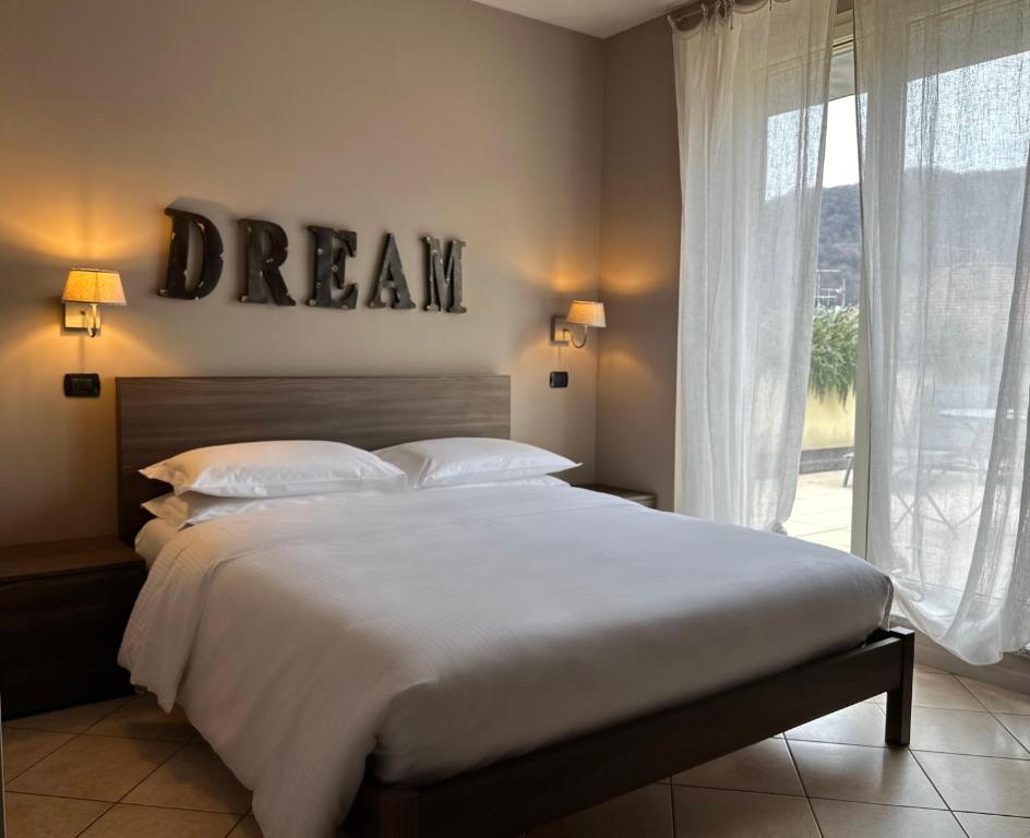 a bedroom with a bed with a dream sign on the wall at Hotel Ristorante San Giuseppe in Cernobbio