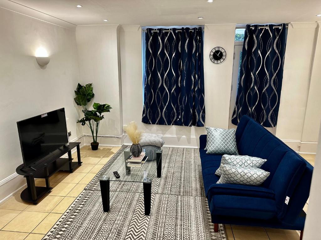 a living room with a blue couch and a piano at 2bed2 bath flat soho in London