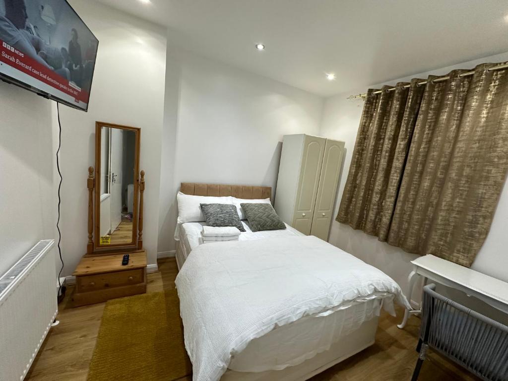 Dormitorio pequeño con cama y espejo en Beautiful Double Room with Free Wi-Fi and free parking, en Lewisham