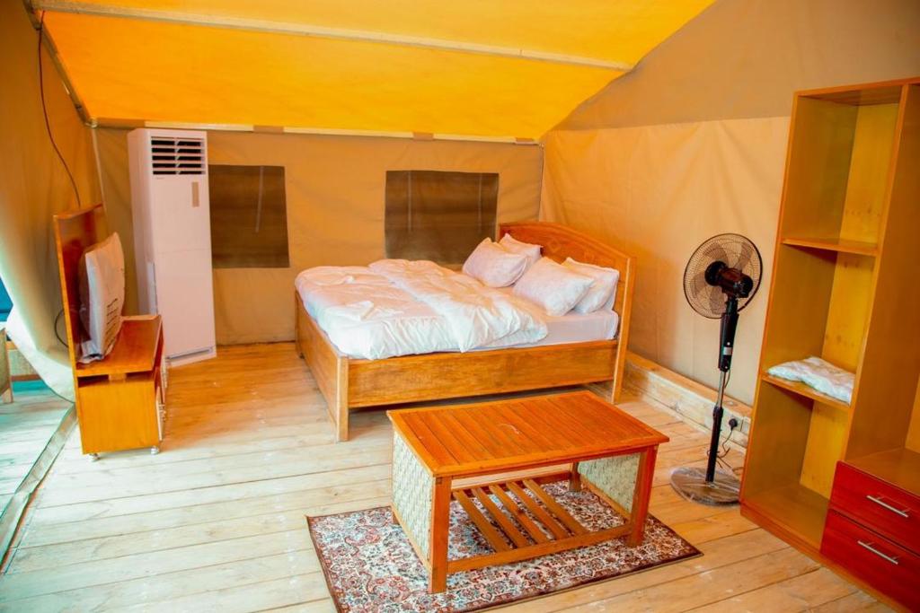 een slaapkamer met een bed in een tent bij Bwawani Gardens in Songea