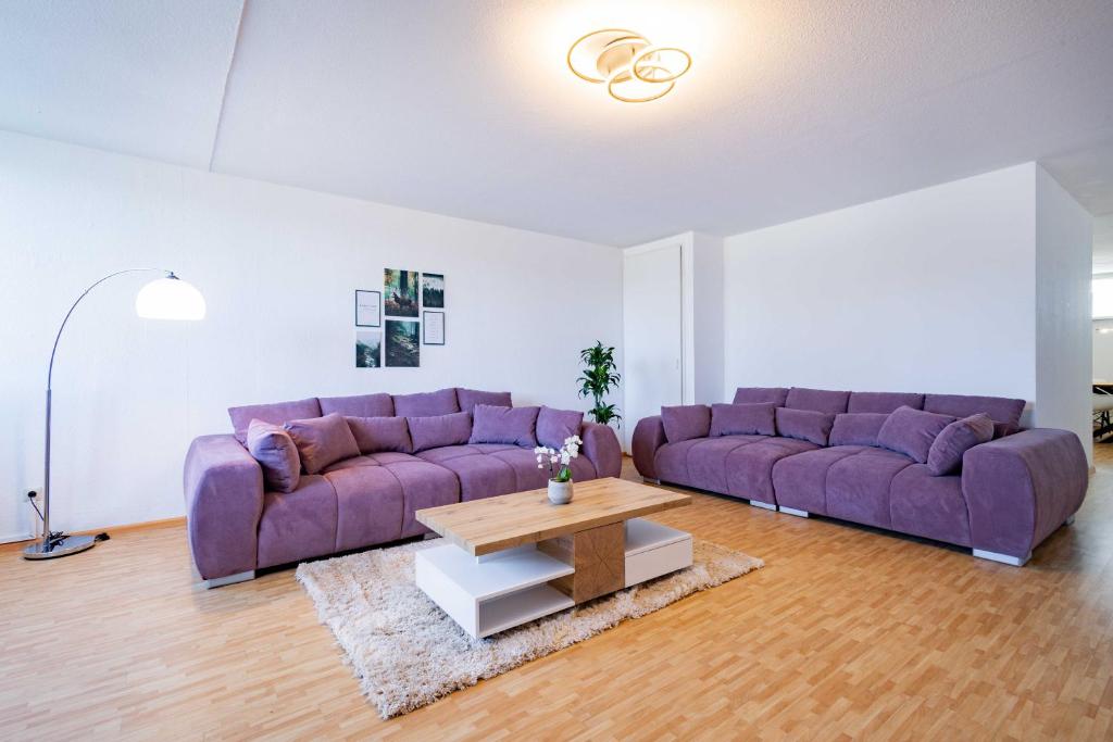 a living room with purple couches and a coffee table at Kim Fewo 2 in Emmendingen