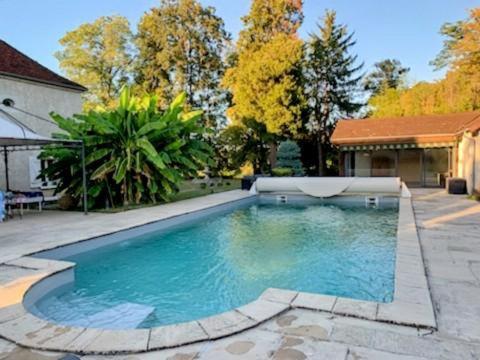 - une piscine dans une cour avec une maison dans l'établissement Le Gîte de l'Hermitage, à Mantoche